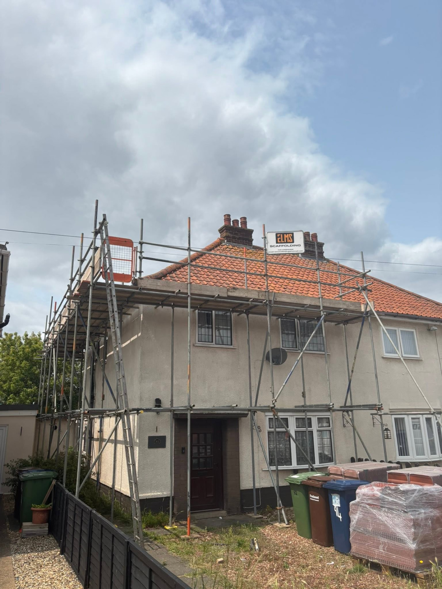 Semi-detached house with Elms Scaffolding scaffold and banner