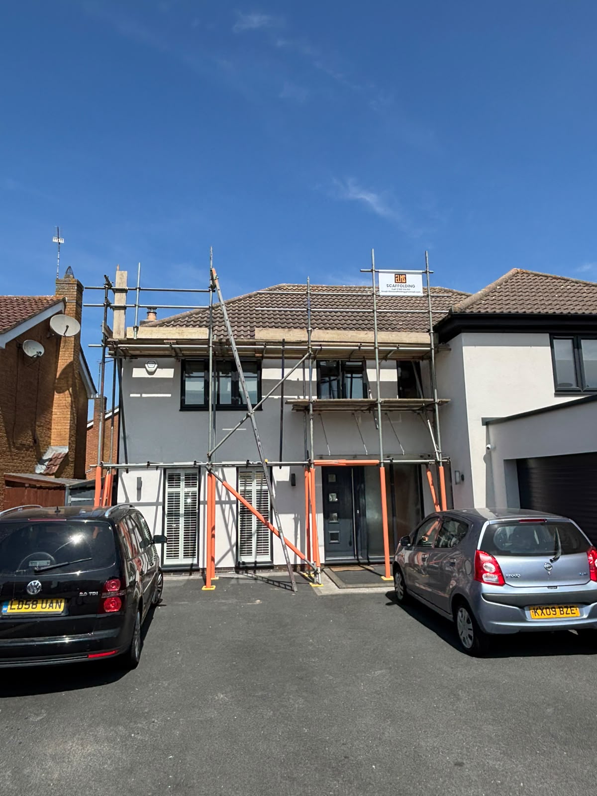 Two-storey rendered house with full scaffold and protected standards